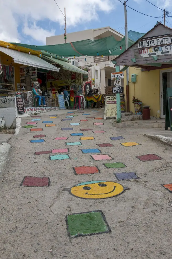 Un smiley et des carrés de couleur sur le sol d'une rue de Matala